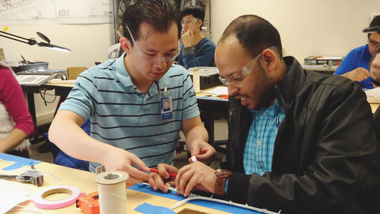Students in the Advanced Manufacturing Skills Center’s Electrical Assembly Mechanic Certificate program team up to bundle wires as part of their hands-on aerospace training. (Credit: AMSC of Edmonds College)